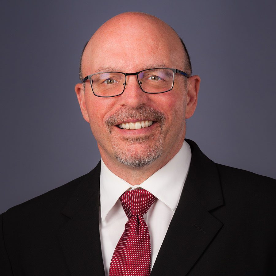 Headshot of male smiling in a suit