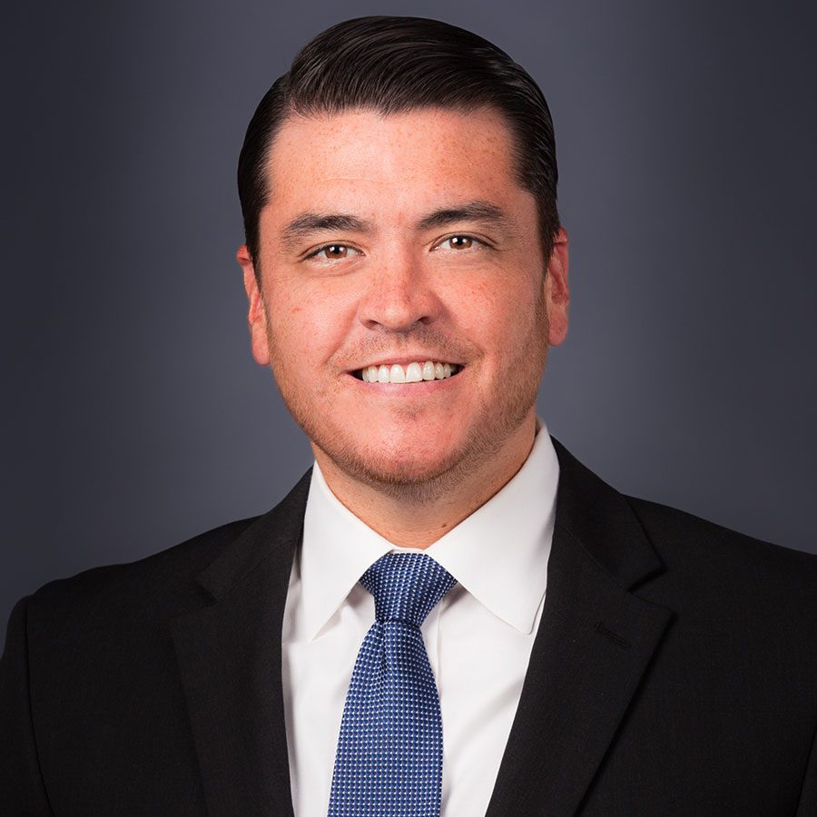 Headshot of male smiling in a suit