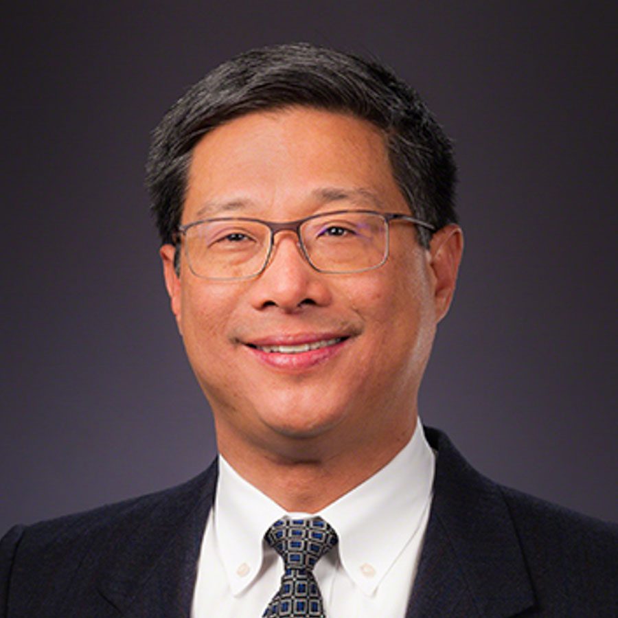 Headshot of male smiling in a suit