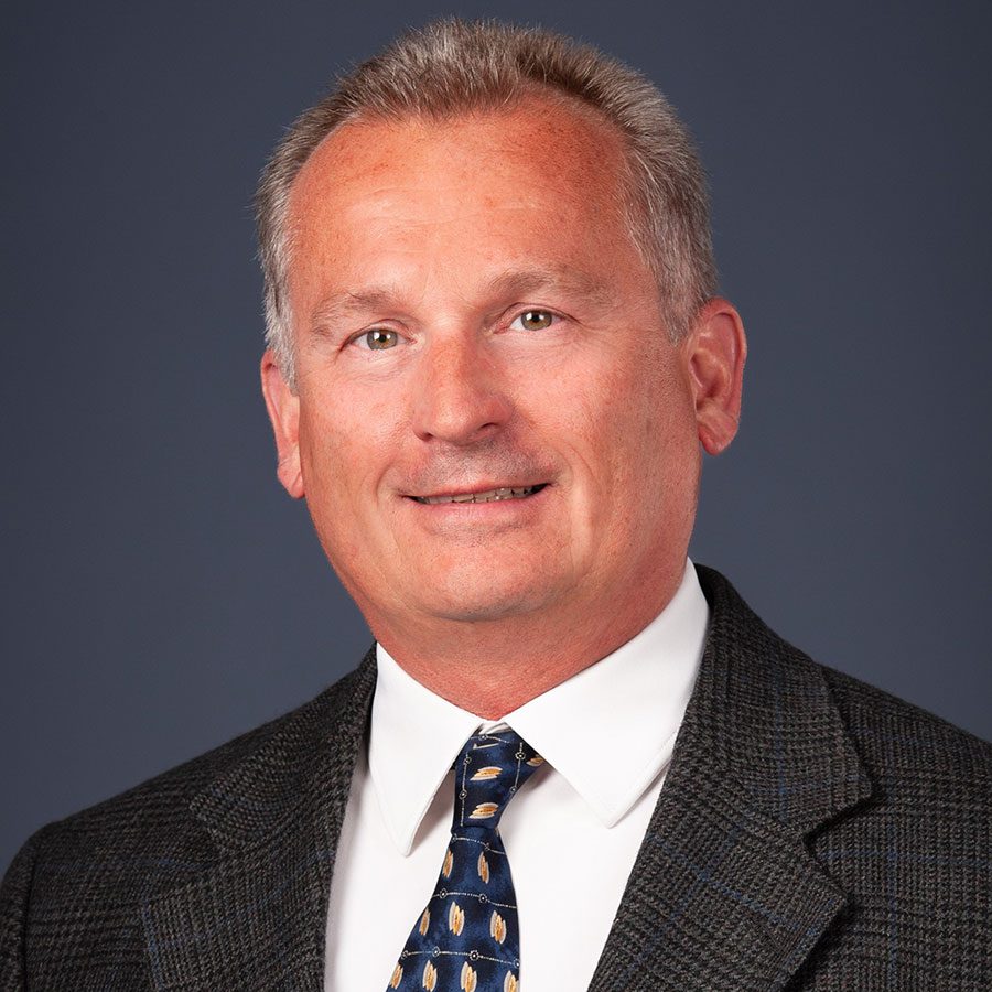 Headshot of male smiling in a suit