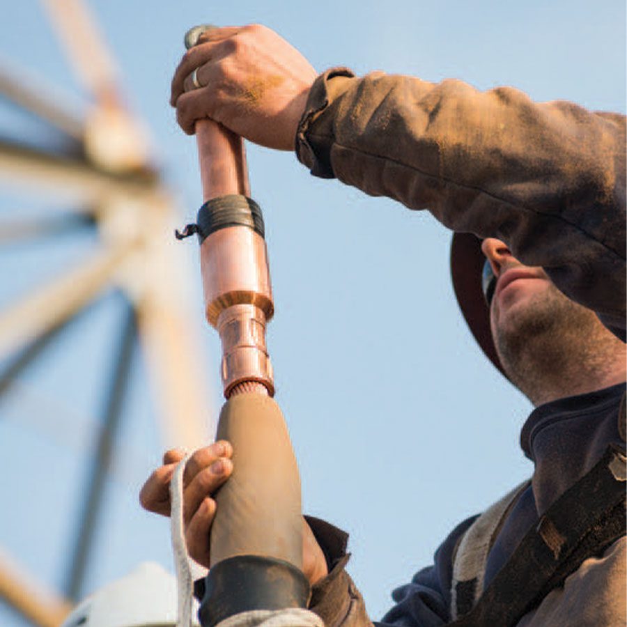 Lineman preparing high voltage cable by cleaning the conductor