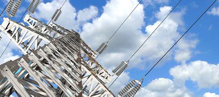 Transmission construction against blue sky with fluffy white clouds