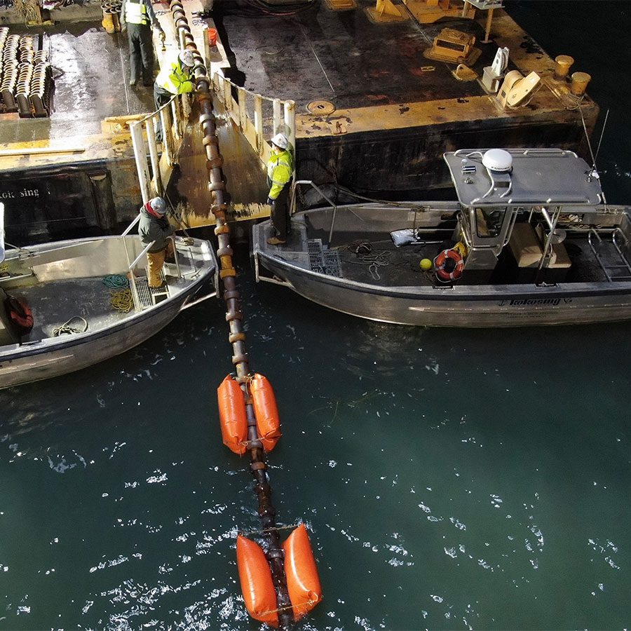 Subsea cable install with cable being pulled from a boat underwater