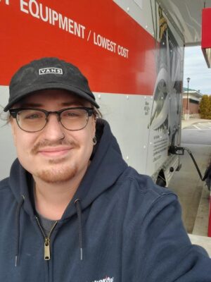 Marmon shipper standing next to an open U-Haul while pumping gas