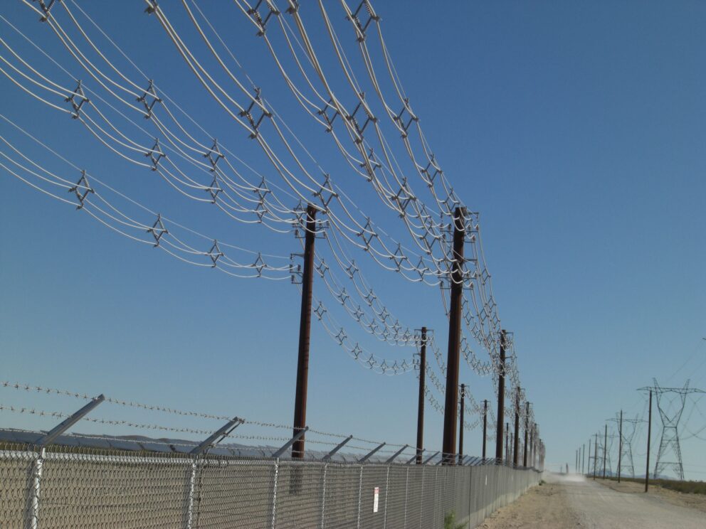 Multi-circuit spacer cable construction across from transmission lines